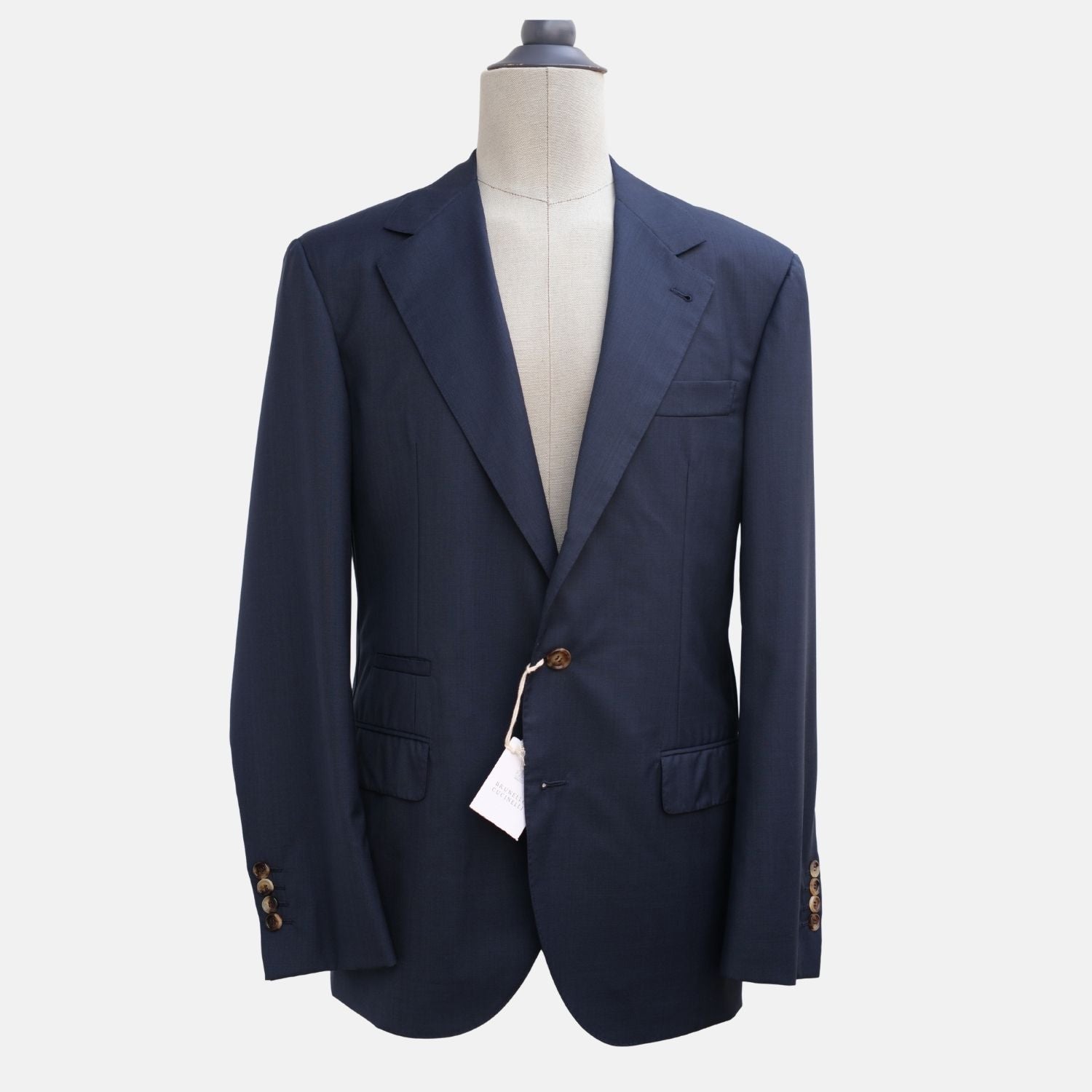Brunello Cucinelli navy blue virgin wool suit jacket on a mannequin, peak lapel with two-button front