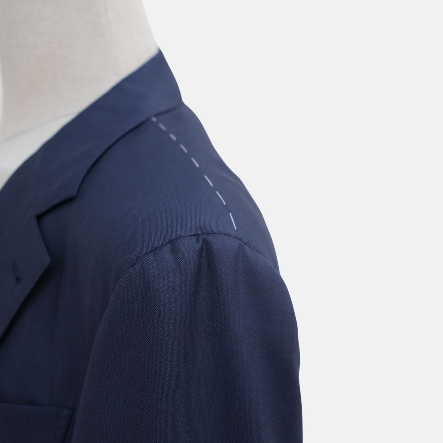 Close-up of the suit jacket's peak lapel and shoulder seam detail