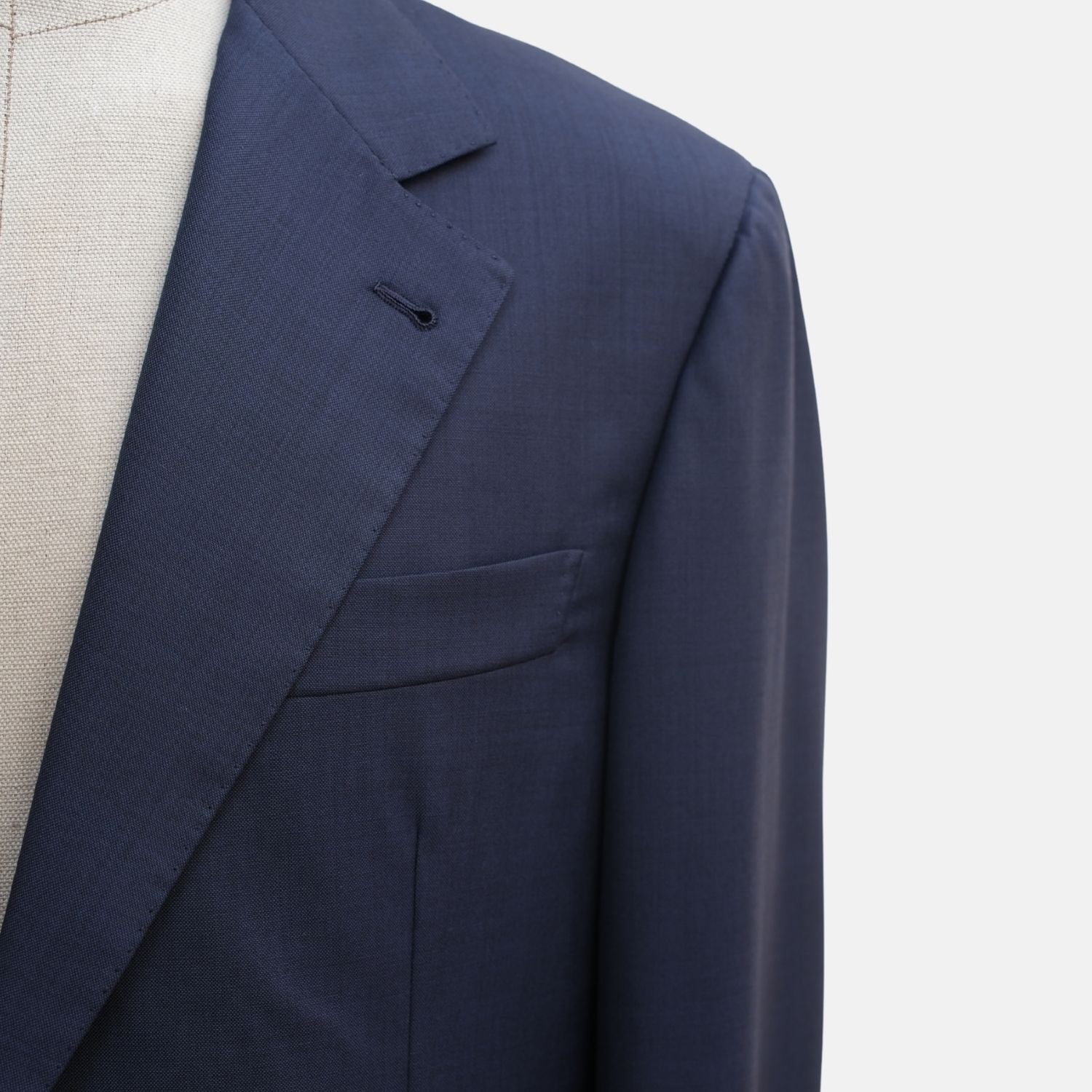 Close-up of the suit jacket's peak lapel, buttonhole and welt breast pocket
