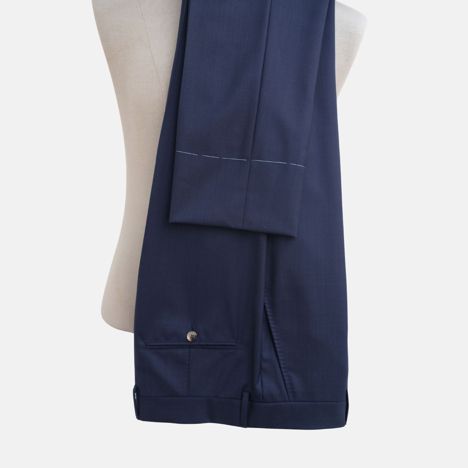 Navy blue Brunello Cucinelli wool suit trousers draped over a mannequin, back view with welt pockets