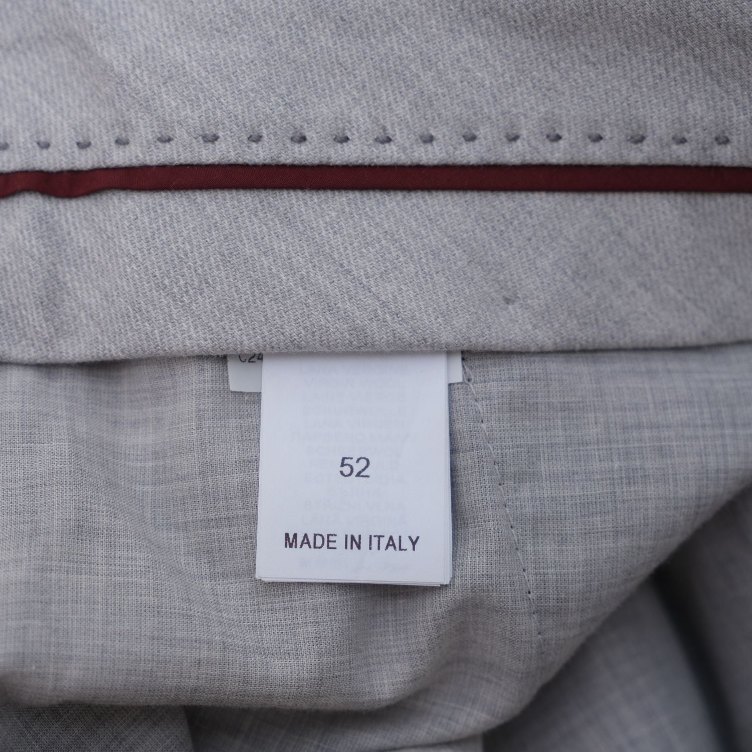 Close-up of the suit trousers' waistband size label showing 52, Made in Italy