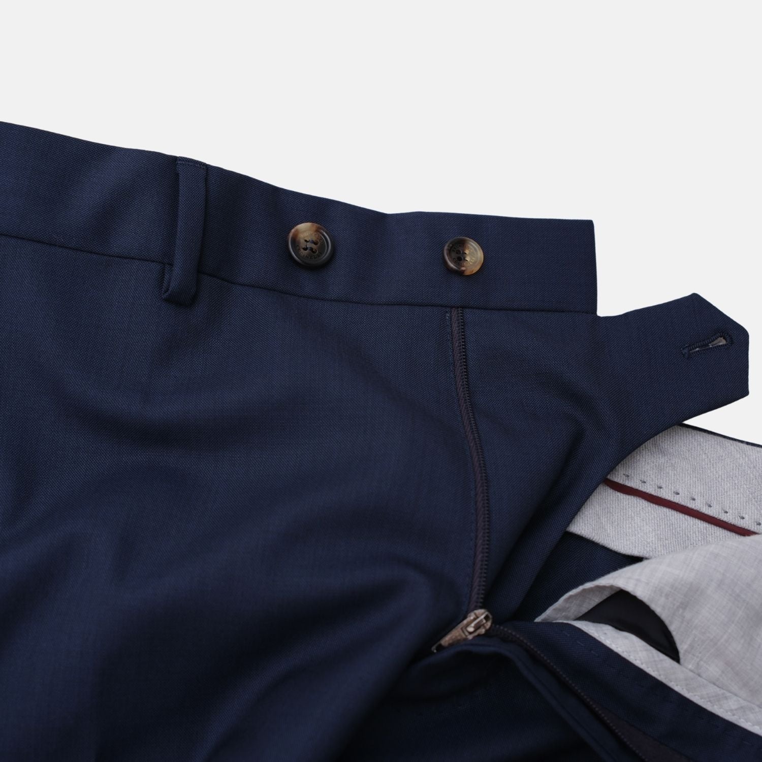 Close-up of the suit trousers' waistband fastening with buttons and zip fly