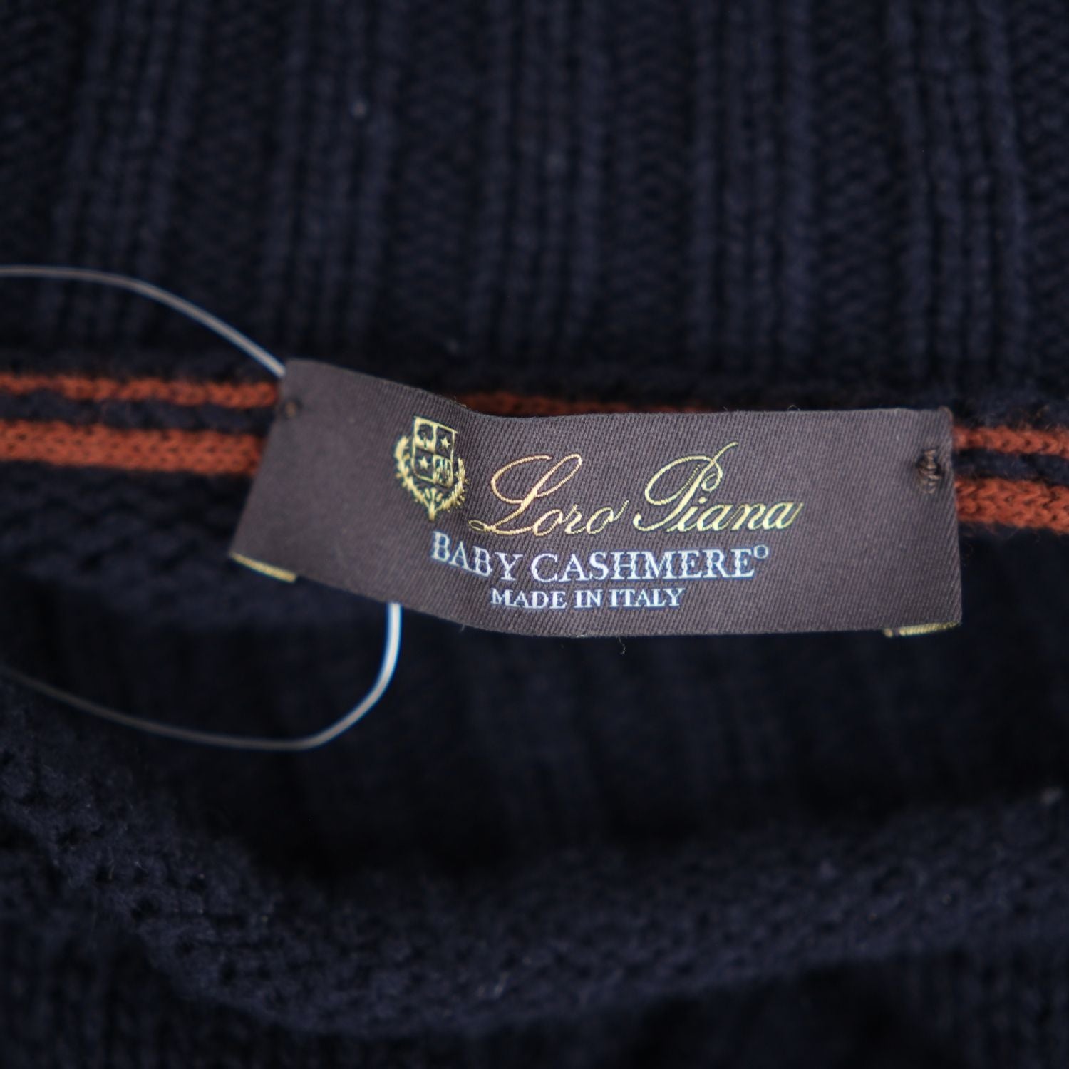 Close-up of the Loro Piana Baby Cashmere brand label sewn into the turtleneck's neckline