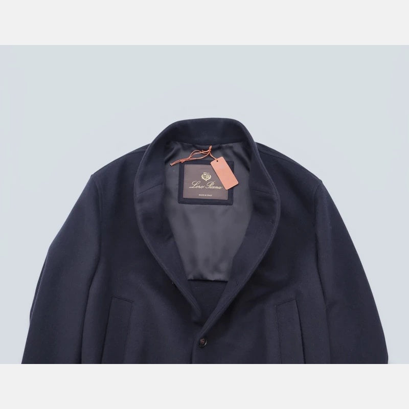 Close-up of the shawl collar on the Loro Piana navy cashmere bomber jacket with brand label and hang tag