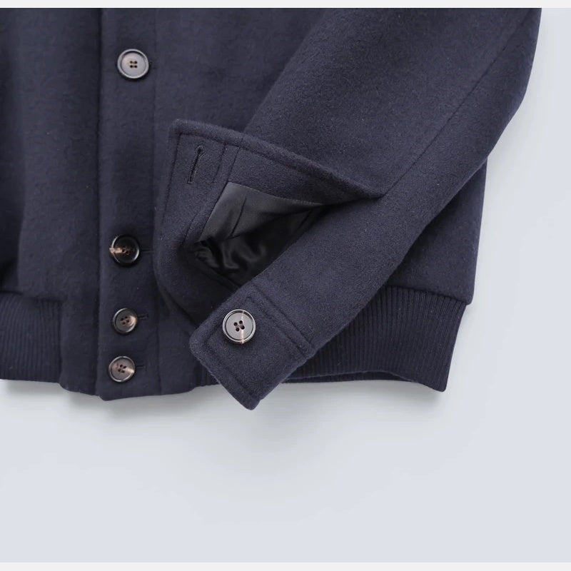 Detail of the button cuff and welt pocket on the Loro Piana navy cashmere bomber jacket