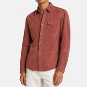 Man wearing a Brunello Cucinelli burgundy suede shearling trucker jacket with snap buttons and western yoke detailing